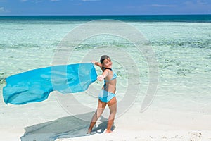 Pretty stylish beautiful little girl walking on the tropical beach