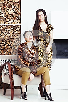 Pretty stylish woman in fashion dress with leopard print together in luxury rich room interior, lifestyle people concept