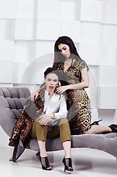 Pretty stylish woman in fashion dress with leopard print together in luxury rich room interior, lifestyle people concept