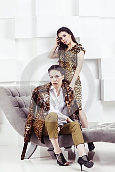 pretty stylish woman in fashion dress with leopard print together in luxury rich room interior, lifestyle people concept