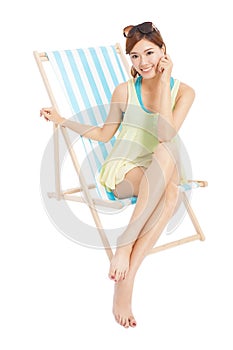 Pretty sunshine girl smiling and sitting on a beach chair