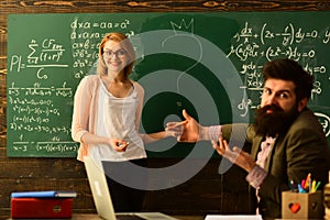 Pretty teacher helping pupil in classroom at the elementary school, International student making individual online