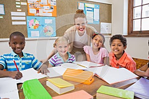 Pretty teacher helping pupils in classroom