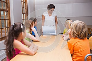 Pěkný učitel zobrazené přenosný počítač na žáci 