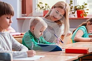 Pretty teacher solves homework together with the student