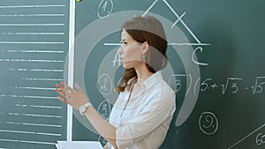 Pretty teacher talking to the pupils in classroom. photo