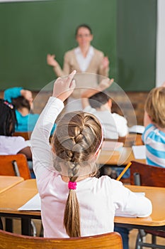 Pretty teacher talking to the young pupils in classroom