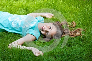 Pretty teen girl lying on the grass. laughter, joy, positive emotions