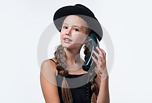 pretty teen girl with pigtails in hat speak on retro phone isolated on white, communication