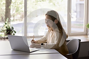 Pretty teen girl wear headphones use laptop e-learns subject