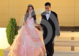 Pretty teen quinceanera birthday girl celebrating in princess dress pink party, special celebration of girl becoming woman.