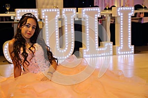 Pretty teen quinceanera birthday girl celebrating in princess dress pink party, special celebration of girl becoming woman.