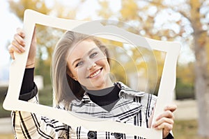 Pretty Teen Smiling in a Park with Picture Frame