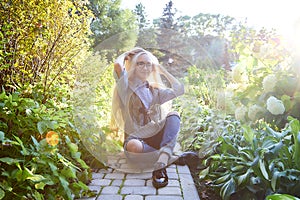 Pretty teenage girl 14-16 year old with curly long blonde hair in the green park in a summer day outdoors. Beautiful portrait