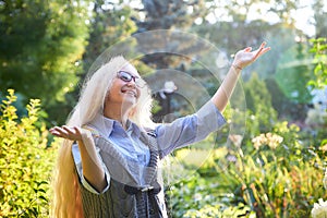 Pretty teenage girl 14-16 year old with curly long blonde hair in the green park in a summer day outdoors. Beautiful portrait