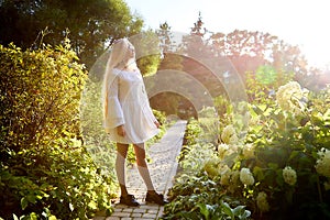 Pretty teenage girl 14-16 year old with curly long blonde hair in the green park in a summer day outdoors. Beautiful portrait