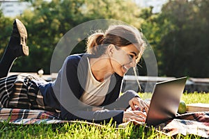 Pretty teenage girl laying on a grass at the park