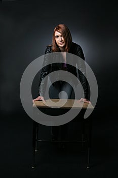 Pretty teenage girl leaning on school desk