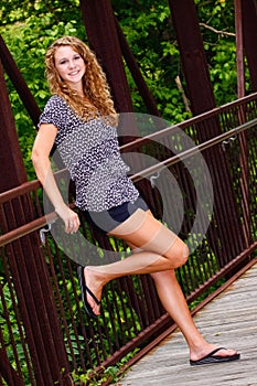 Pretty Teenage Girl Relaxing on a Bridge