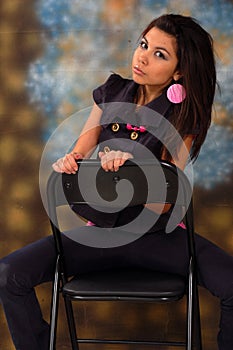 Pretty teenage girl seated on a chair