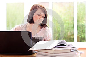 Pretty teenage girl studying at home