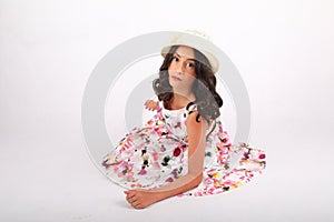 Pretty teenage girl in summer dress and white hat