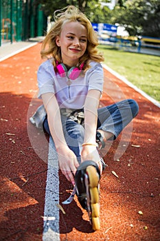 Pretty Teenage Girl Wearing Roller Skaters On The Road In Summe Park.