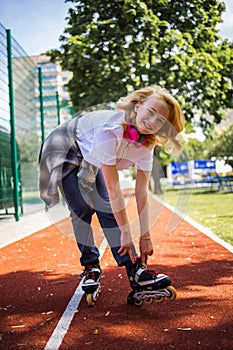 Pretty Teenage Girl Wearing Roller Skaters On The Road In Summe Park. photo