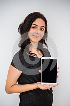 Pretty teenager girl holds tablet. Mock up with schoolgirl and black screen