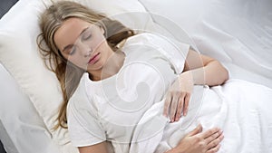Pretty teenager peacefully sleeping in bed, relaxing in morning, dream, top-view