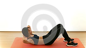 Pretty Thai Asian girl is doing crunch sit-up cardio workout exercise in white background in fitness show concept