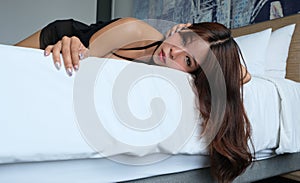 Pretty Thai woman lies on a bed