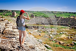 Pretty tourist woman with backpack at the ruins of ancient city of Perge near Antalya Turkey photo