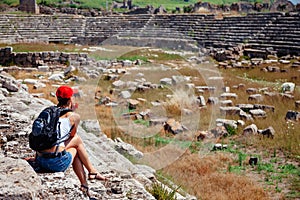 Pretty tourist woman with backpack at the ruins of ancient city of Perge near Antalya Turkey photo