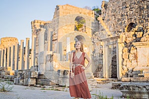 Pretty tourist woman at the ruins of ancient city of Perge near Antalya Turkey photo