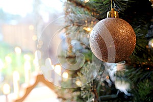 Pretty traditional gold Christmas tree bauble hanging near a win