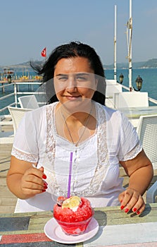Pretty Turkish Woman with White Dress eating Turkish dessert Bici Bici photo