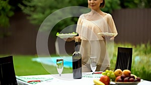 Pretty waiter serving table for celebration in country house, catering service