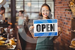 Pretty waitress posing with open sign