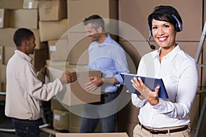 Pretty warehouse manager using tablet during busy period