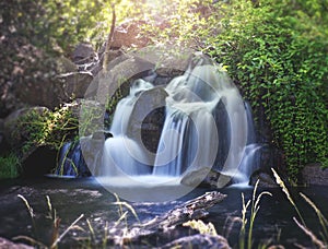 Pretty waterfall with slow shutterspeed for cascading water softening with a vintage retro instagram filter