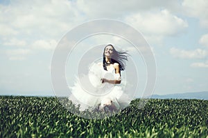 Pretty wedding girl on green grass and sky