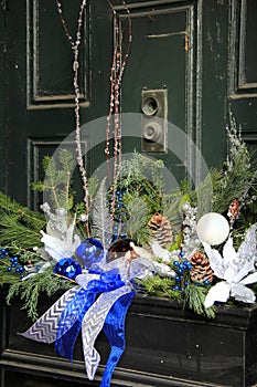 Pretty window box with seasonal decorations on green door