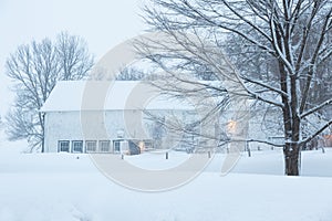Pretty winter early morning landscape with large white wooden barn in field