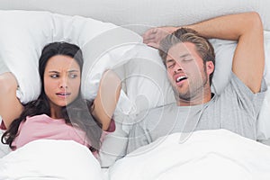 Pretty woman annoyed by the snoring of her husband