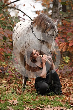 Pretty woman with appaloosa horse in autumn