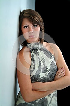 Pretty Woman with Arms Folded Leaning Against Wall