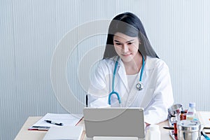 Pretty woman, Asian doctor is using a computer To save data Symptomatic
