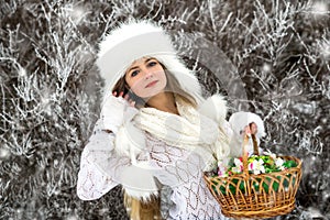 Pretty woman with baskets and white sweater, fur cap in winter snow park