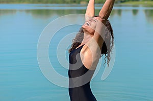 Pretty woman in bathing suit reaching up
